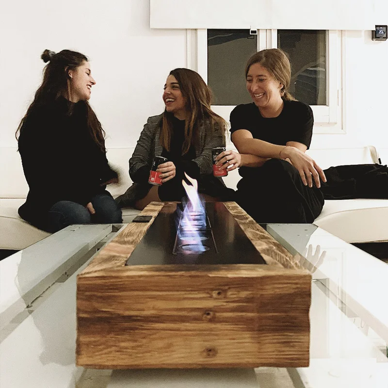 Mujeres platicando y riendo frente a chimenea